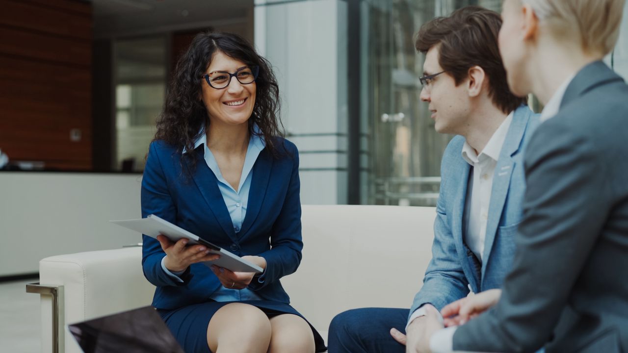 about-01 Professionals discussing business strategy in a corporate office setting.